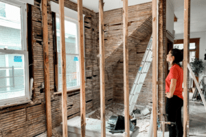Woman in unfinished room during renovation; Can Tile Installation Increase Home Value